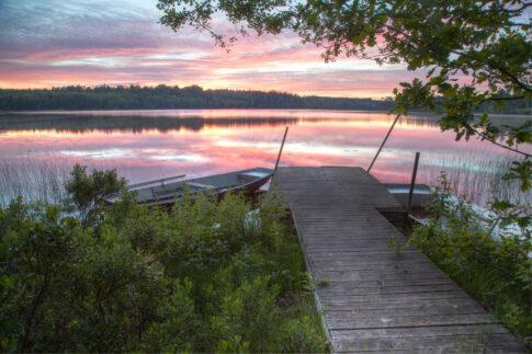 Sunset over Lake Alljungen with a wooden pier extending into the water.
